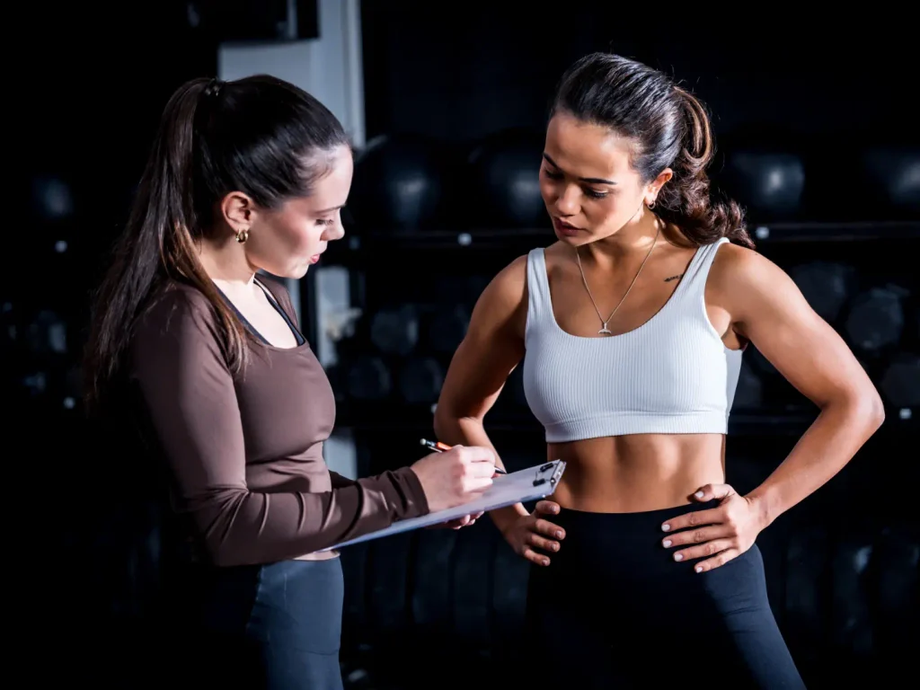 Coach notant les objectifs d'une adhérente lors d'un premier bilan